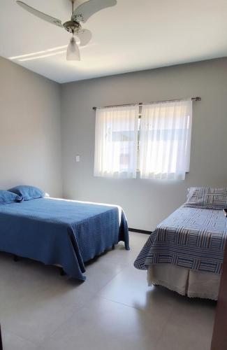 a bedroom with two beds and a ceiling fan at loft climatizado em Timóteo próximo à Aperam, Ipatinga e Coronel Fabriciano in Timóteo