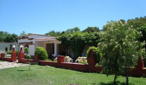 una casa con una recinzione di fronte a un cortile di Hosteria Calamuchita a Villa del Dique