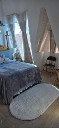 a bedroom with a bed with a rug and a window at Martha's House Audi in Soufrière