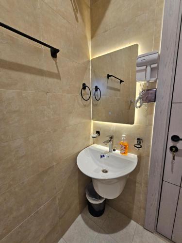 een badkamer met een wastafel en een spiegel bij Sinkhole Chalet in Bimmah