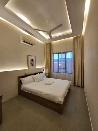 een slaapkamer met een groot wit bed met een raam bij Sinkhole Chalet in Bimmah