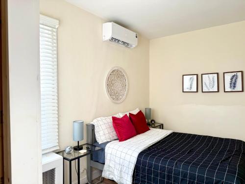 a bedroom with a blue and white bed with red pillows at 2-A Diamond in Yonkers in Yonkers