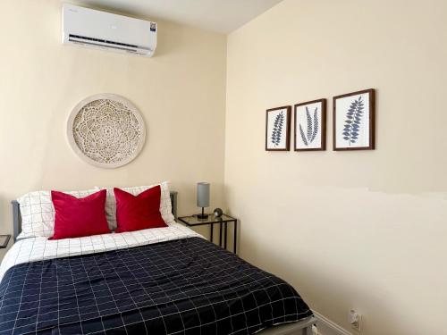 a bedroom with a bed with red pillows at 2-A Diamond in Yonkers in Yonkers