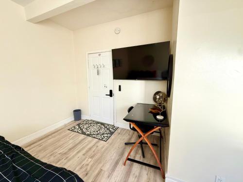 een slaapkamer met een bureau en een televisie in een kamer bij 2-A Diamond in Yonkers in Yonkers