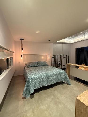 una camera da letto con un letto con un piumone verde di Complejo Raíces a Mar de Cobo