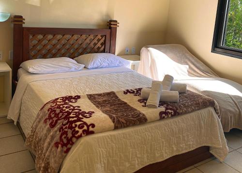 een slaapkamer met twee bedden met daarop een kruis bij Pousada Pedra Bonita in Cristal