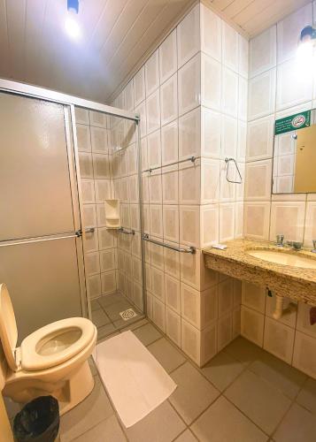 a bathroom with a shower and a toilet and a sink at Pousada Pedra Bonita in Cristal