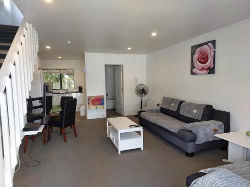 a living room with a couch and a table at Camellia Court Motel in Lower Hutt