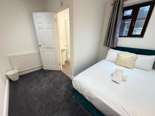 a small bedroom with a bed and a bathroom at Moor Layover Heathrow - Cozy Crew Stay - 10 min to Airport in Harmondsworth