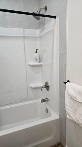 a white bathroom with a tub and a sink at Elian's Nest in Saskatoon