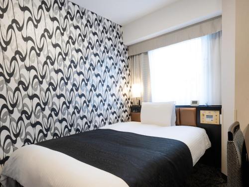 a bedroom with a black and white patterned wall at APA Hotel Kintetsu Nara Ekimae in Nara