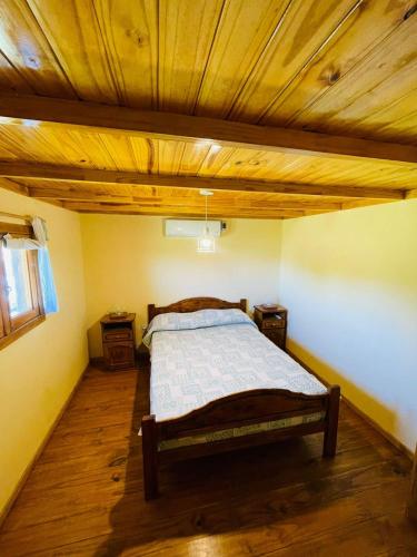 a bedroom with a bed with a wooden ceiling at Cabaña 4 in Necochea