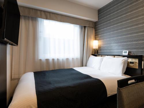 a hotel room with a bed and a window at APA Hotel Kintetsu Nara Ekimae in Nara