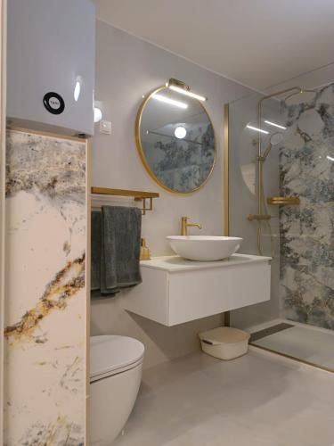 a bathroom with a sink and a toilet and a mirror at Paulla in Šibenik