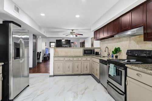 a large kitchen with wooden cabinets and appliances at 6 Bedroom house 15 minutes from iah airport. in Houston