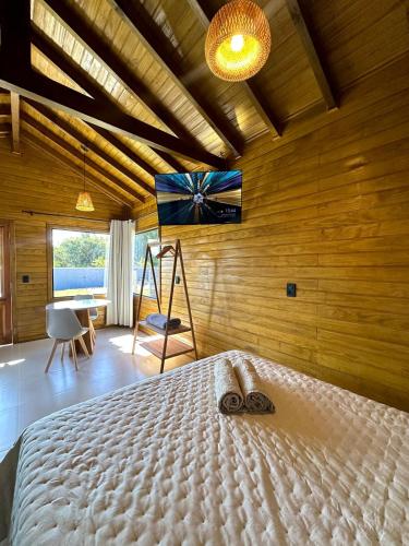 a bedroom with a bed in a room with wooden walls at Cabana Raiz & Mar - 01 in Imbituba