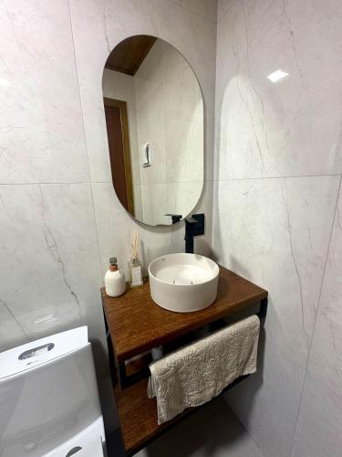 a bathroom with a sink and a mirror at Cabana Raiz & Mar - 01 in Imbituba
