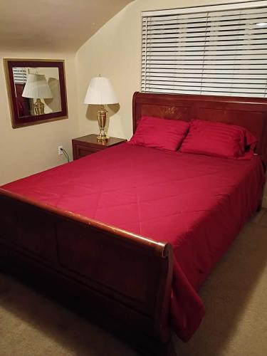 a bedroom with a large red bed with red pillows at Historic Reno Home in Reno