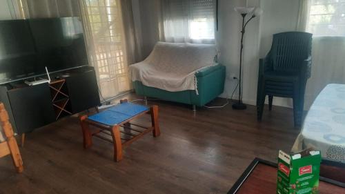 ein Wohnzimmer mit Sofa und Fernseher in der Unterkunft Chalet Bilu in Piriápolis