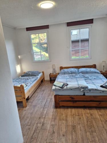 two beds in a room with two windows at Bungalov Rozarka in Růžová