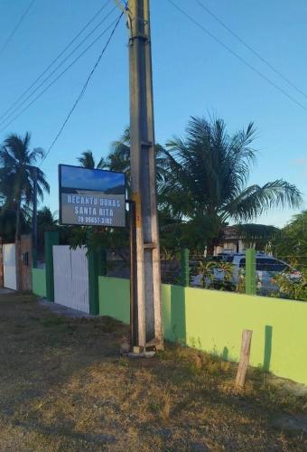 a sign on a pole next to a fence at Recanto Dunas Santa Rita in Estância
