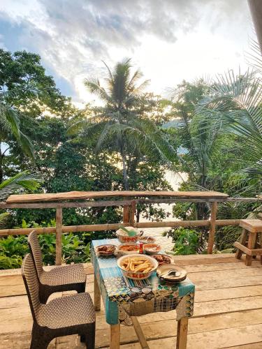 a table with a plate of food on a deck at SIRUS Resort Tagulandang in Kisihang