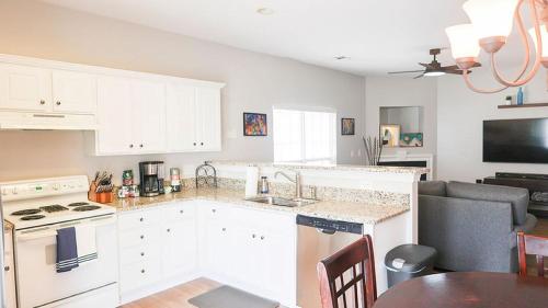 a kitchen with white cabinets and a table in a room at The Cozy Hub in Simpsonville