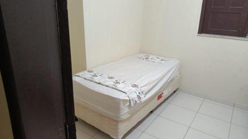 a small bed in a corner of a room at Recanto Dunas Santa Rita in Estância