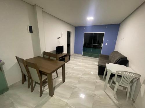 a living room with a table and chairs and a couch at Ap Seabra 2 quartos in Seabra