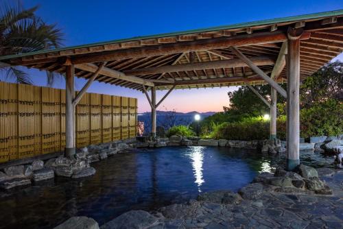 a wooden pergola over a pool of water at Higaki Hotel in Gamagōri