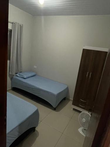 a small room with two beds and a dresser at Casa da Villa Santa Rita in João Pessoa
