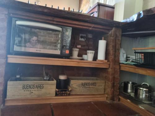 a microwave sitting on a shelf in a kitchen at Cabaña Loft Los Grillos in Mar de Ajó