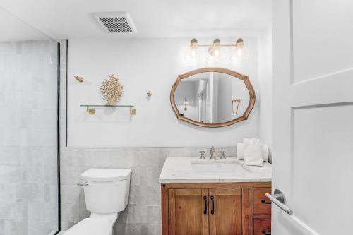 a bathroom with a toilet and a sink and a mirror at Anchor Inn & Cottages in Sanibel