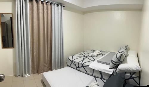 a room with two twin beds and a window at Cozy Nook in the City in Manila