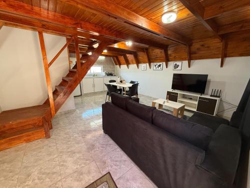 a living room with a couch and a television at Cabañas Alpinas M&M in Perito Moreno