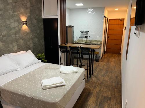 a bedroom with a bed and a kitchen with a sink at Pousada Verde Serrath - Muriqui in Vila Muriqui