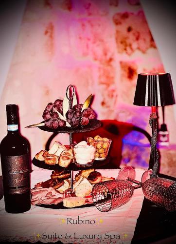 a table with a plate of food and a bottle of wine at Rubino Private SPA & Room in Corato