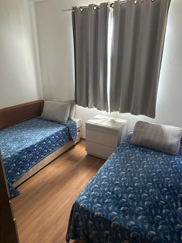 een kleine kamer met twee bedden en een raam bij Aconchego Moro- Apto708, T-2 in Barra Velha