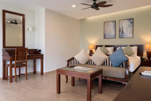 un salon avec un canapé et une table dans l'établissement Frangipani Langkawi Resort, à Pantai Cenang