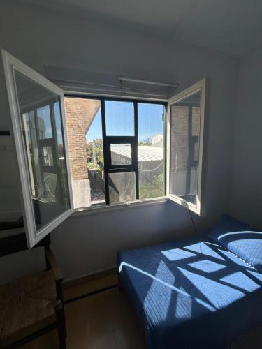 a bedroom with a bed and a large window at Irape in La Paloma