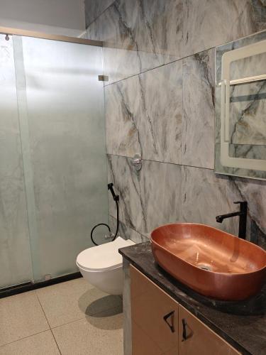 a bathroom with a copper sink and a toilet at Horizon vue Villas in Rājahmundry