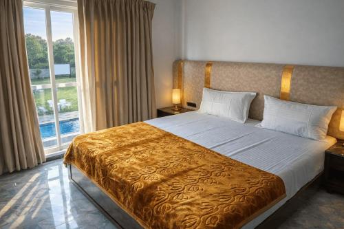 a bedroom with a large bed with a large window at Horizon vue Villas in Rājahmundry