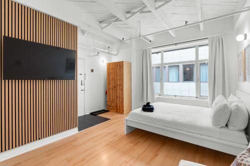 a bedroom with a bed and a large window at Métropolitain Le Cachet in Quebec City