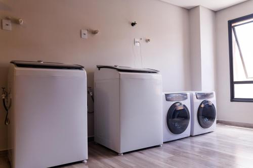 3 lavatrici e lavatrice e asciugatrice in camera di Lou Suites - 15 - Cantinho Charmoso a Guarapuava