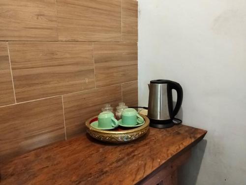 a table with a coffee pot and cups on it at Bali namping in Petang