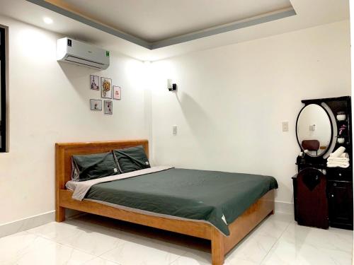 ein Schlafzimmer mit einem Bett und einem Spiegel in der Unterkunft Win House Huế in Thôn Dương Phẩm