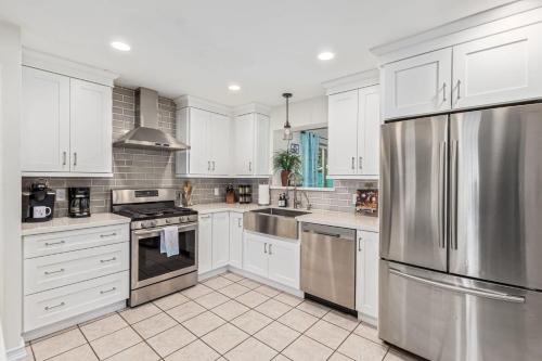 a kitchen with white cabinets and stainless steel appliances at Cozy Tempe Casa with Heated Pool 5 Minutes to ASU in Tempe