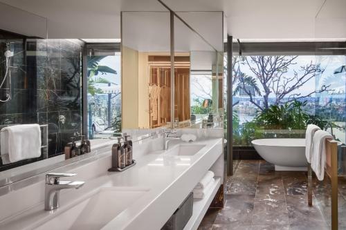 a bathroom with two sinks and a bath tub and a tubermott at Emporium Hotel South Bank in Brisbane