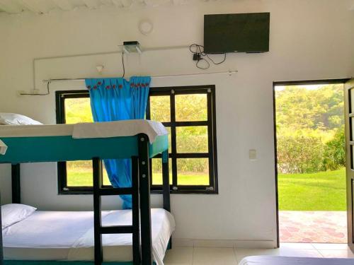 a bedroom with a bunk bed and a tv at Finca Tres Potrillos Villeta in Villeta