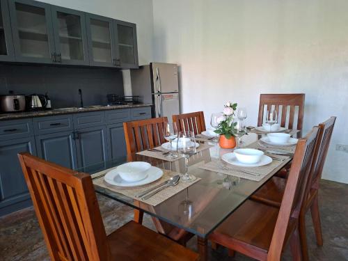 un tavolo da pranzo con 4 sedie e una cucina di Villas Flora Bella a Dauis